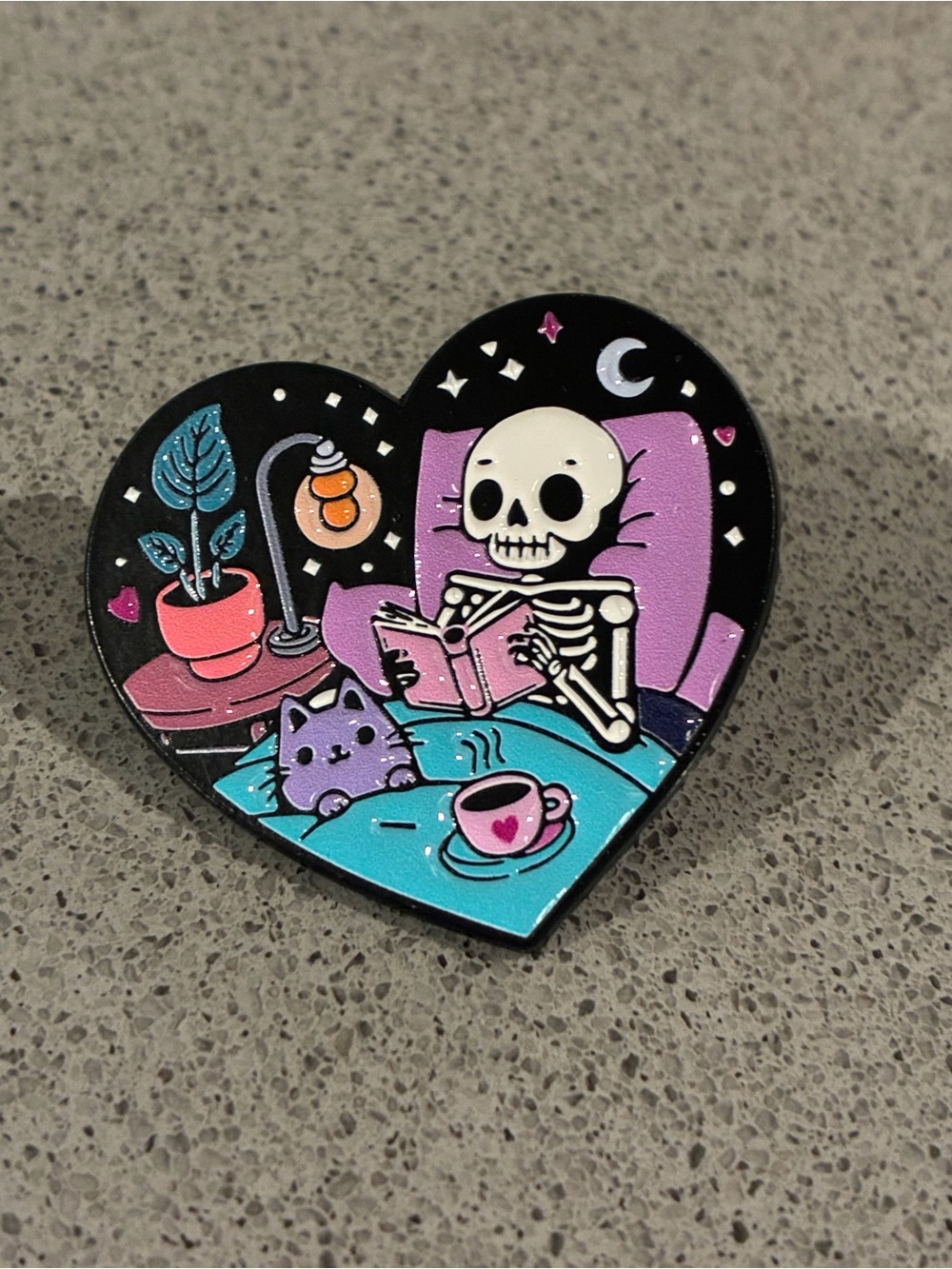 Heart-Shaped Enamel Pin — Skeleton Reading with Cat (Black, Purple, Teal)